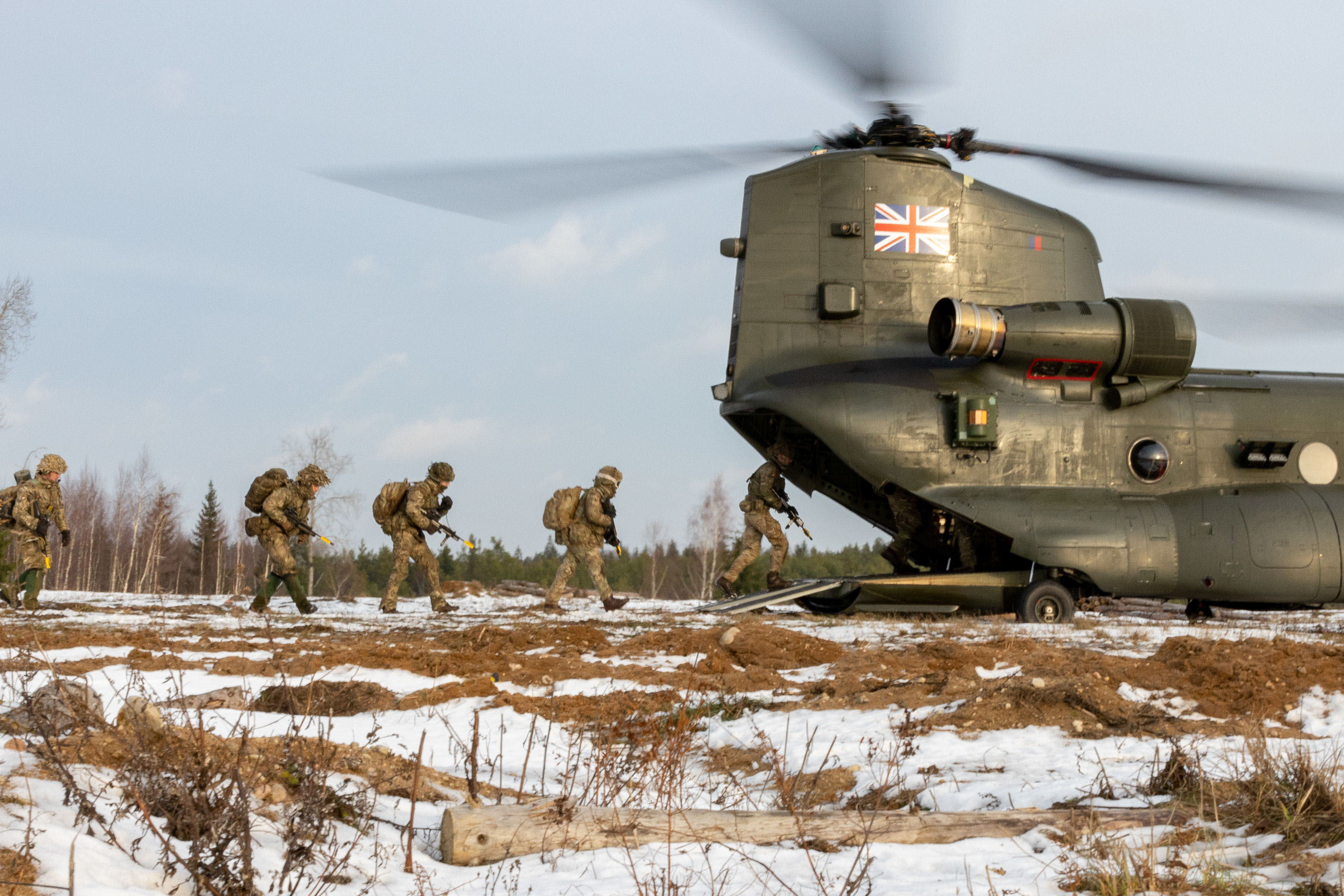 British soldiers board an RAF Chinook in snowy Estonia during Exercise Winter Camp.