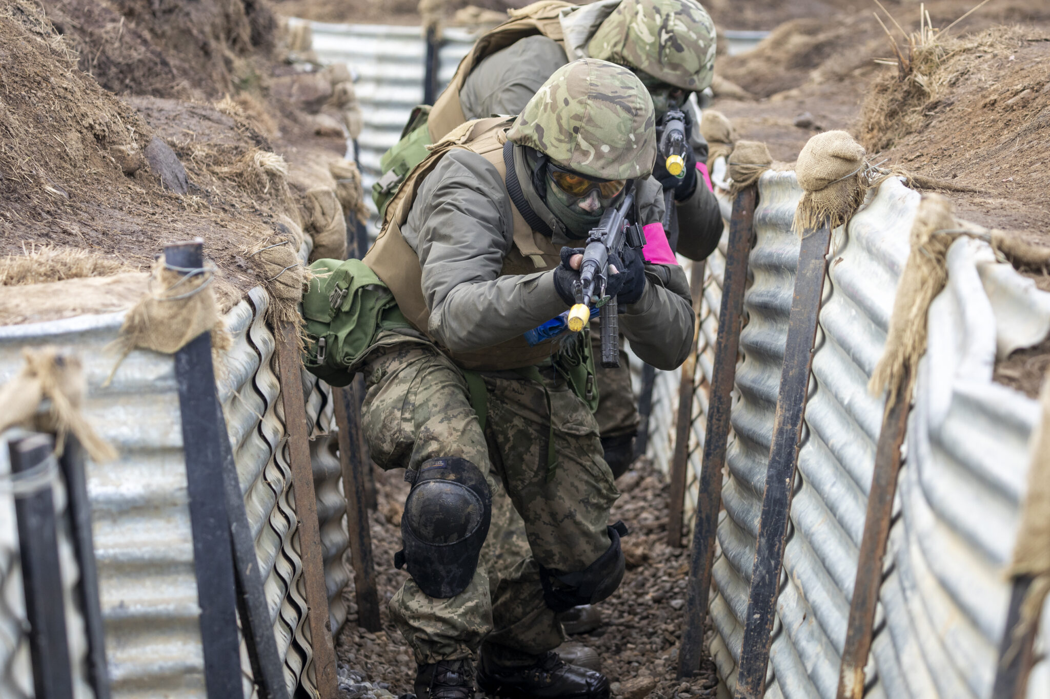 Ukrainian volunteers practise in a trench system during training in north-west England.